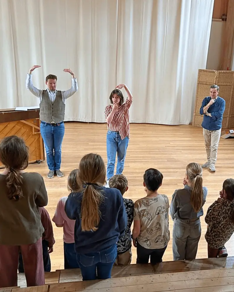 An IVC opera singer leading a vocal workshop with primary-school children